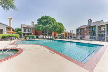 A large swimming pool surrounded by a red brick border.